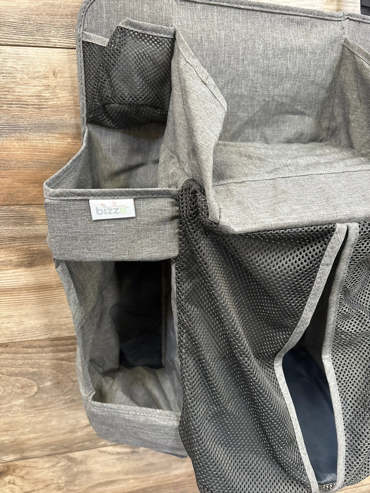 Gray fabric and mesh diaper caddy organizer with multiple compartments on wood background
