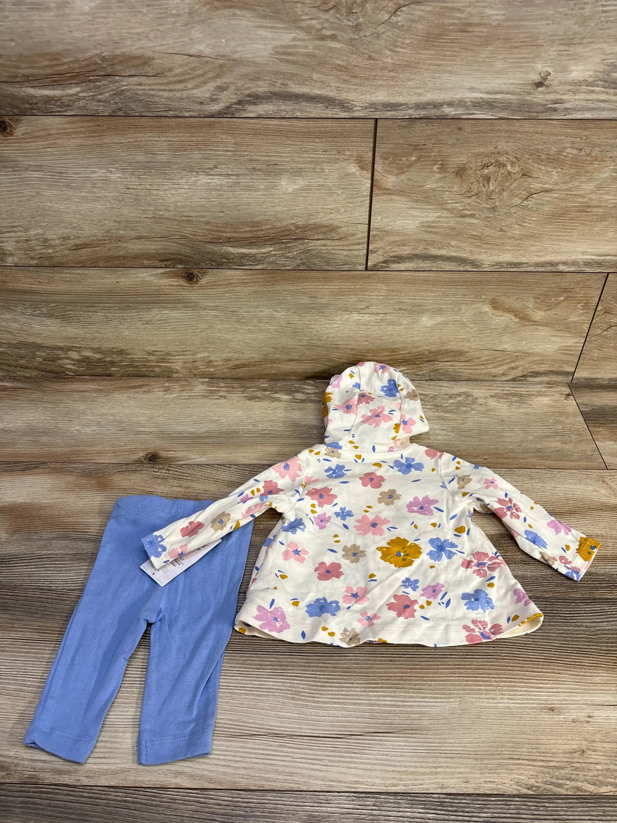 Front view of Just One You 2-piece jacket and pants set, size 3M, with hood, floral print, blue pants, and wood floor