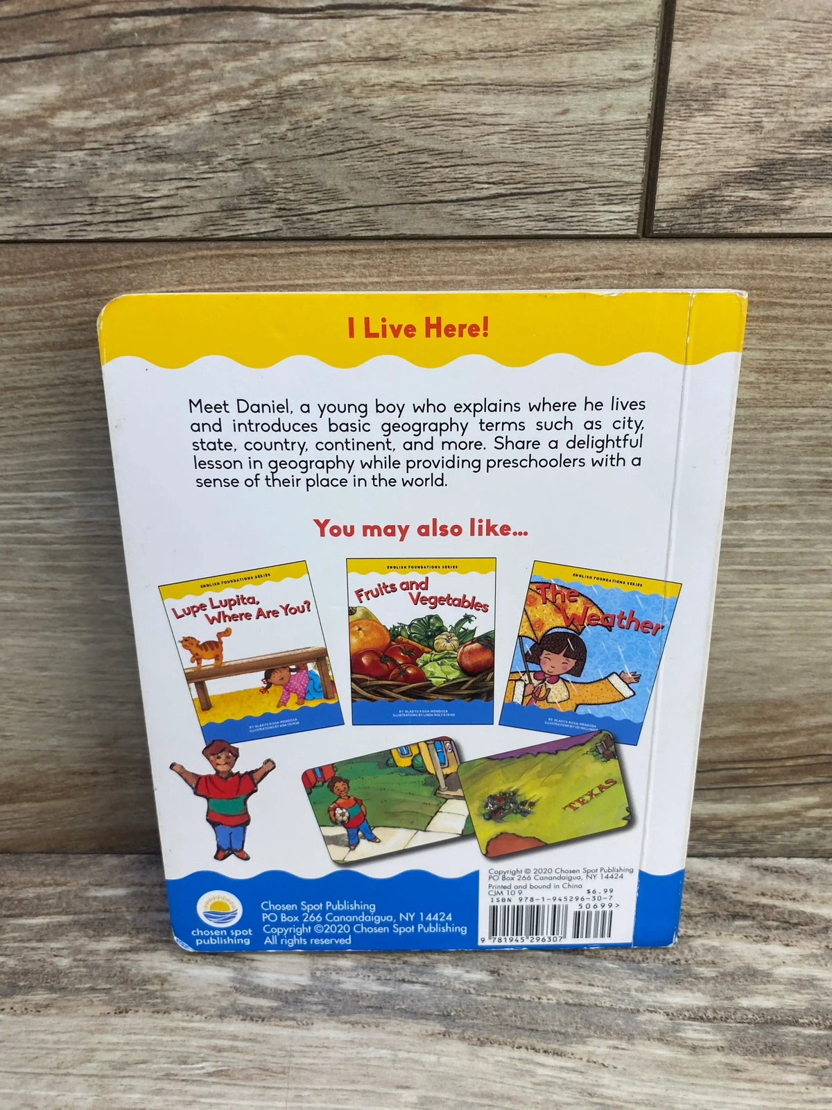 Back cover of I Live Here! board book showing synopsis text and ‘You may also like’ recommendation images against a wood background