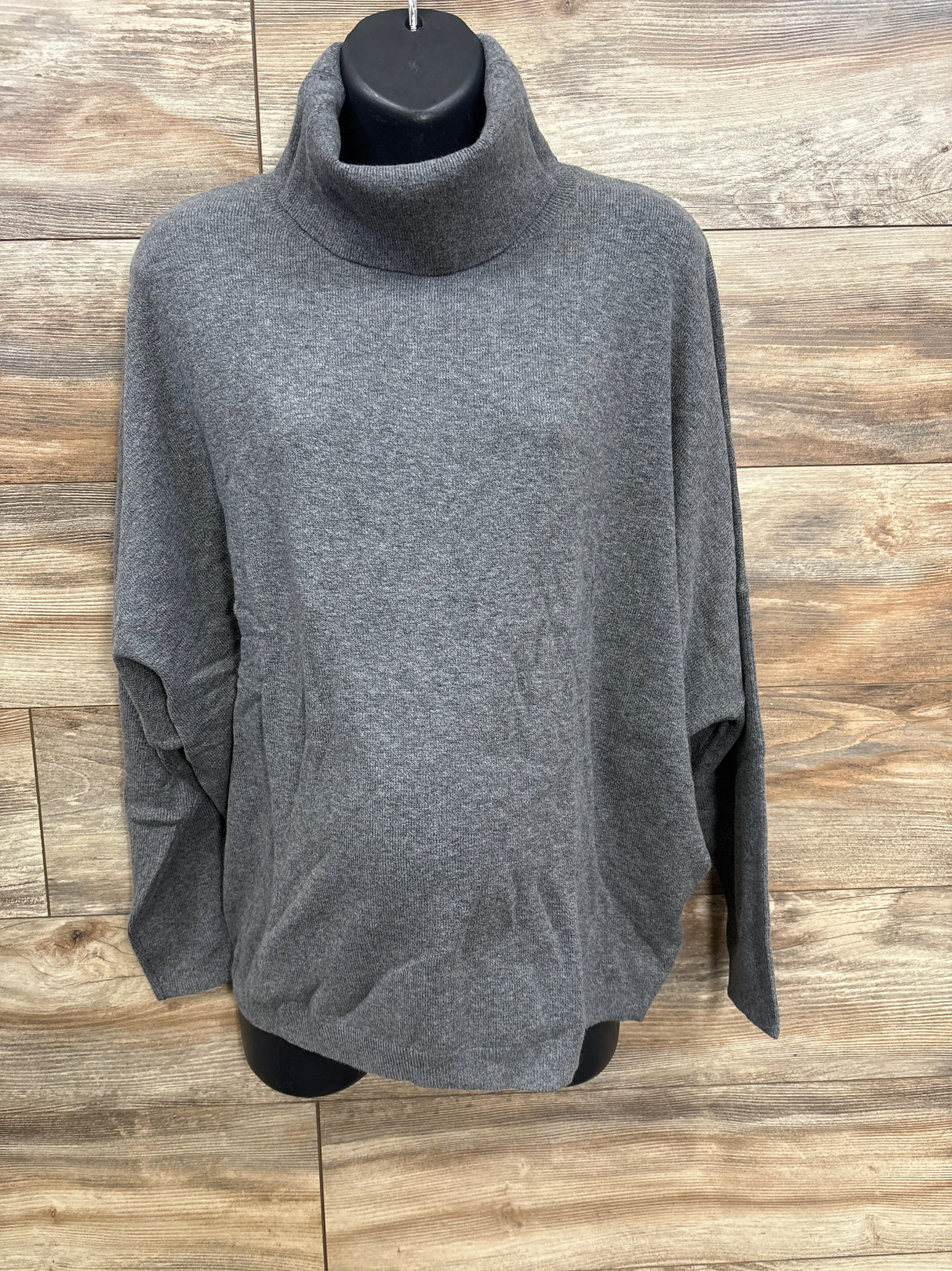 Grey turtleneck sweater on black mannequin against wooden background, kids resale clothing