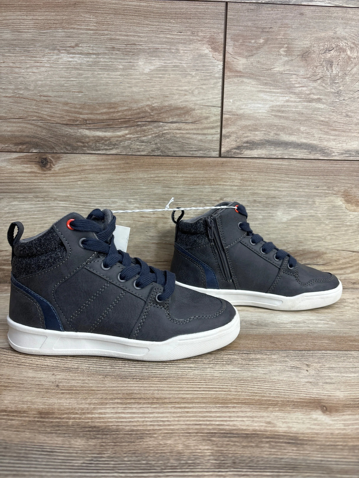 Toddler boy gray high-top sneakers with navy accents and white soles on wood floor
