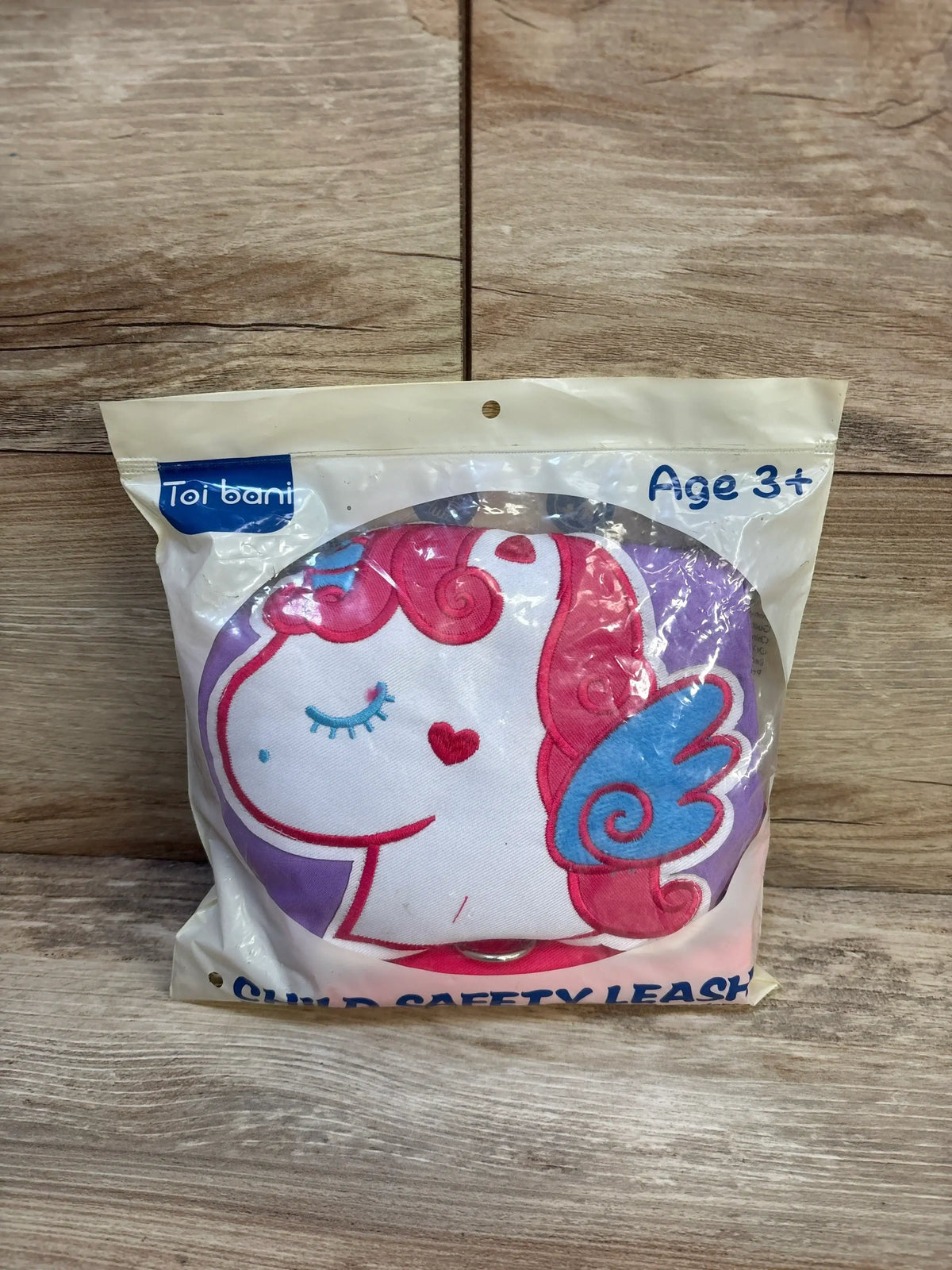 Unicorn child safety leash with pink mane and blue wing, packaged for ages 3 and up