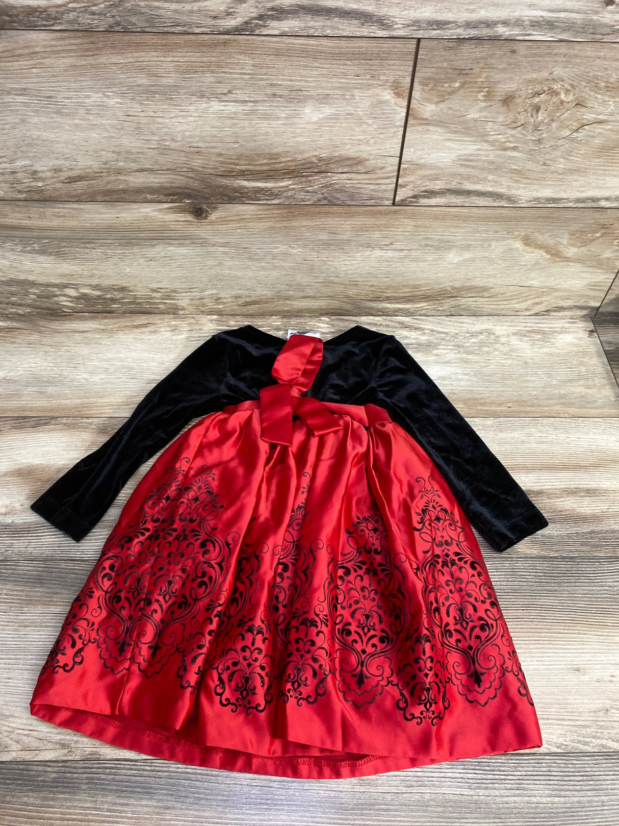 Girls' black velvet and red satin dress with bow and ornate floral pattern, holiday formal wear