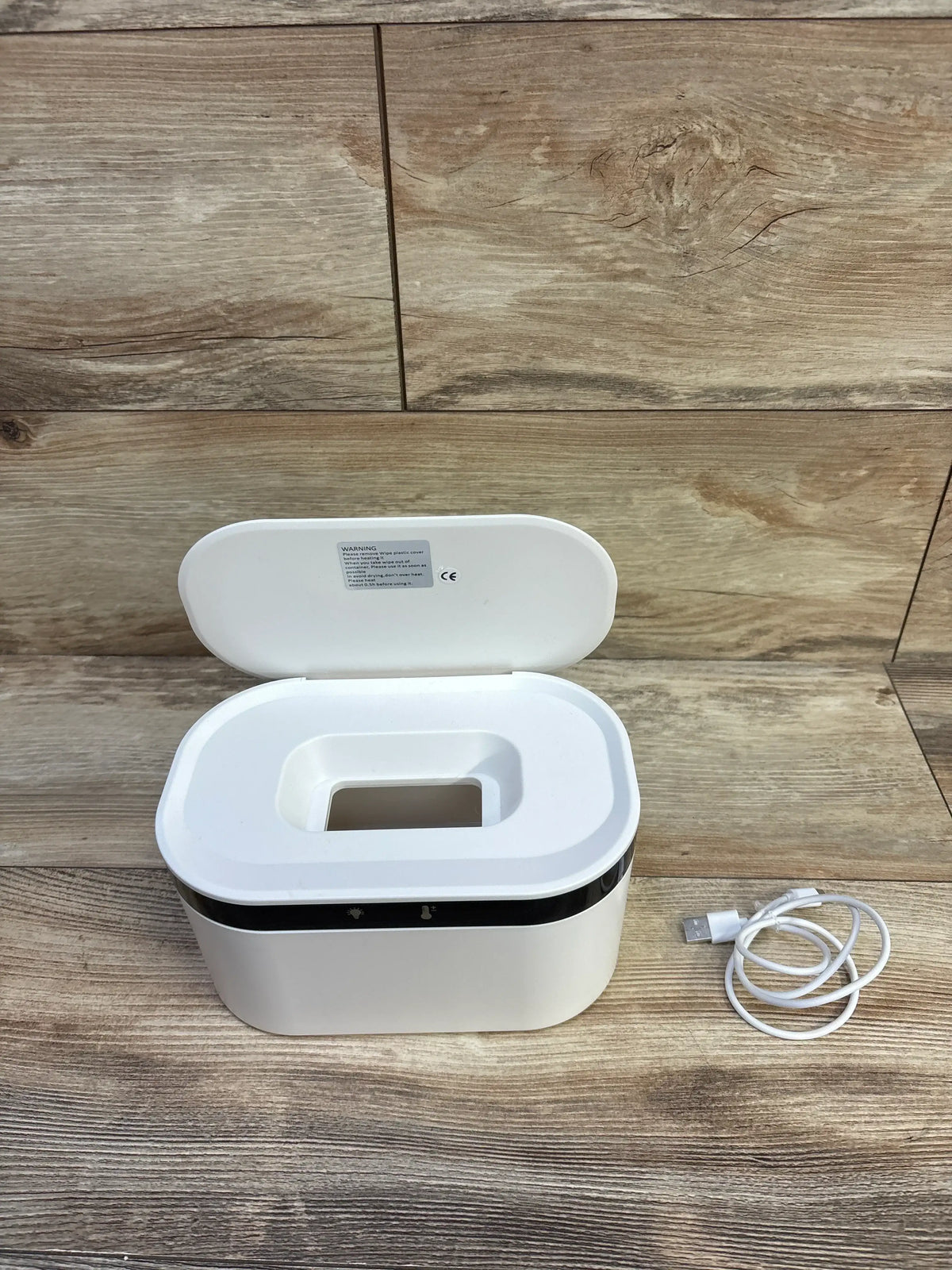 Front view of ZJchao USB baby wipes heater with lid open showing dispensing opening and USB cable on wooden surface