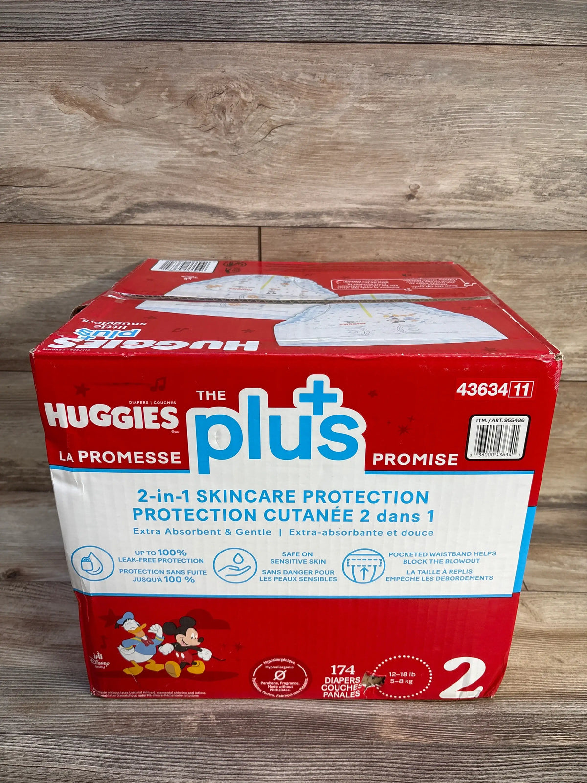 Front view of Huggies Plus Little Snugglers diapers, size 2, showing 2-in-1 skincare protection on wood