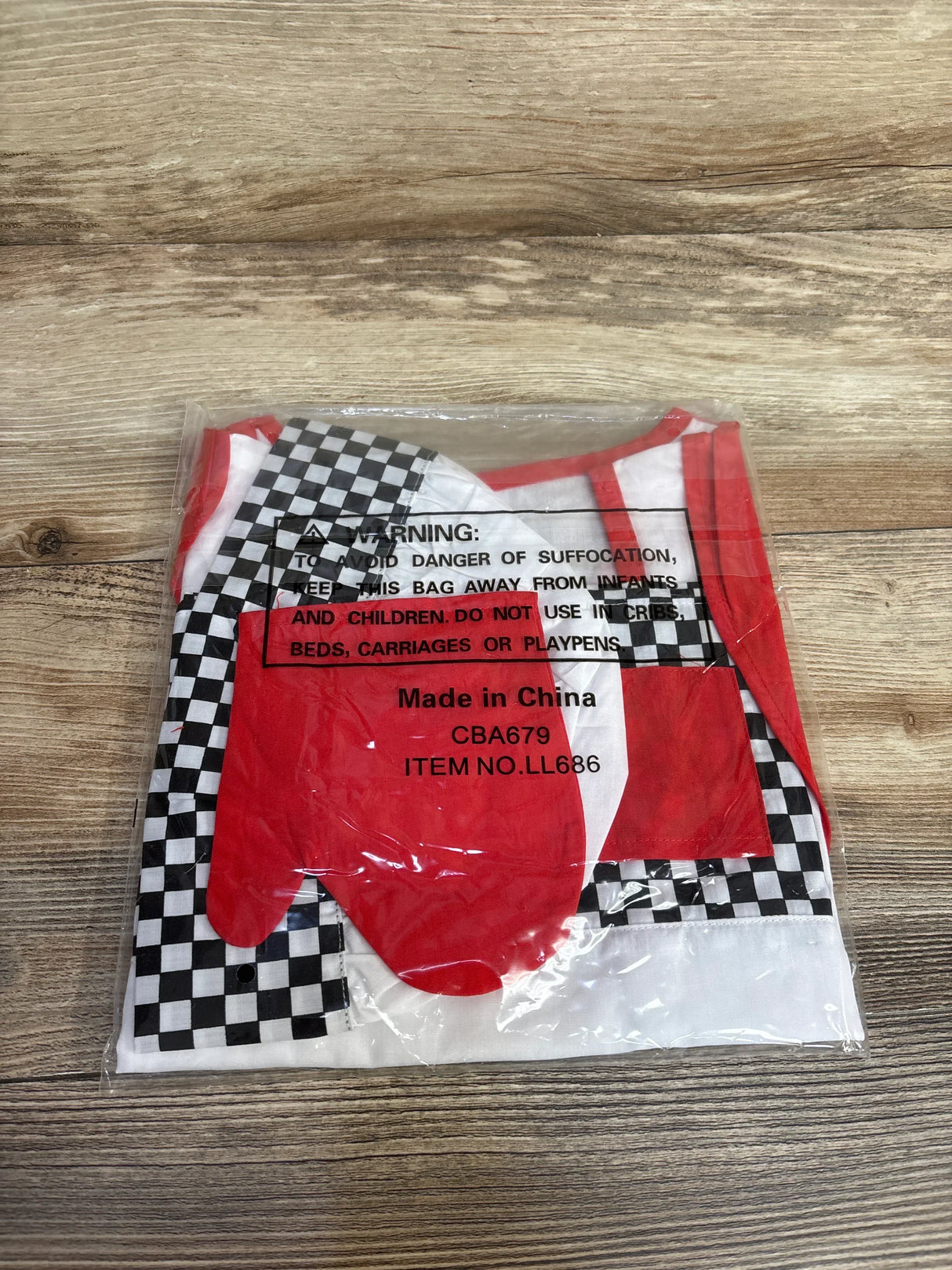 Red and white baby bib with black and white checkered pattern, packaged for resale