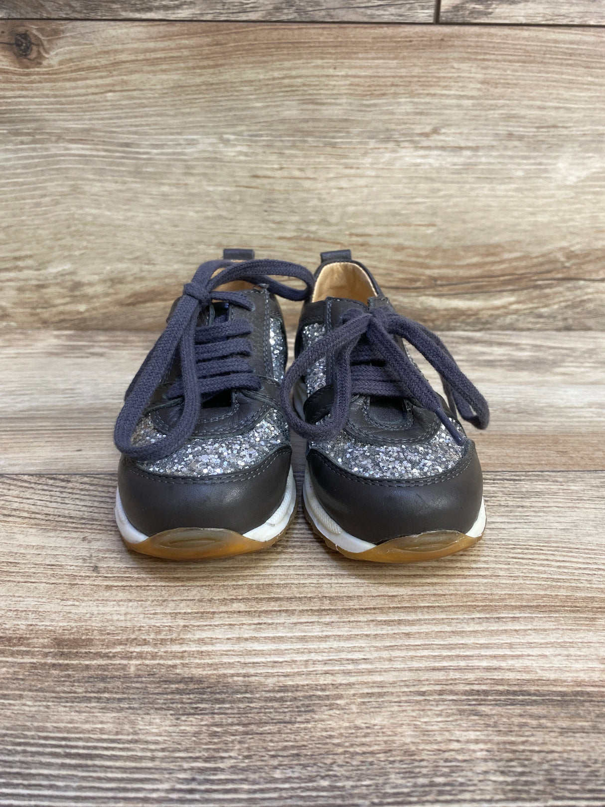 Front view Angulus toddler glitter sneakers size 7C with silver glitter panels, grey leather toe and navy laces on wood floor