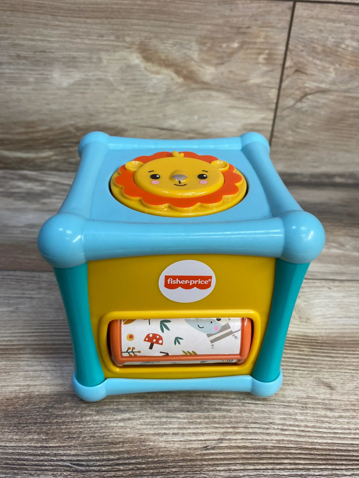 Fisher-Price blue and yellow baby toy block with lion face and woodland print roller