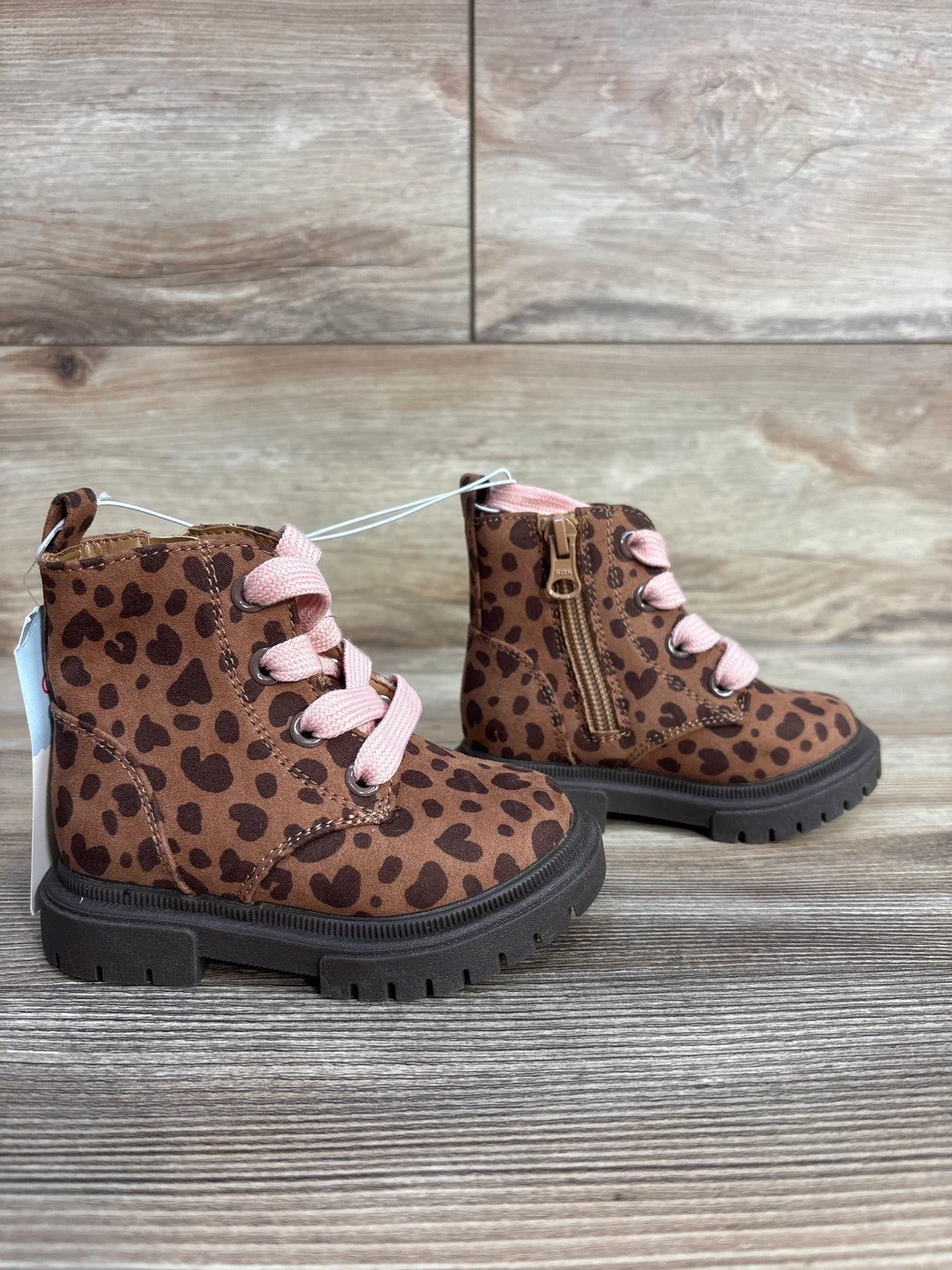 Toddler brown leopard print boots with pink laces and black soles on wood background