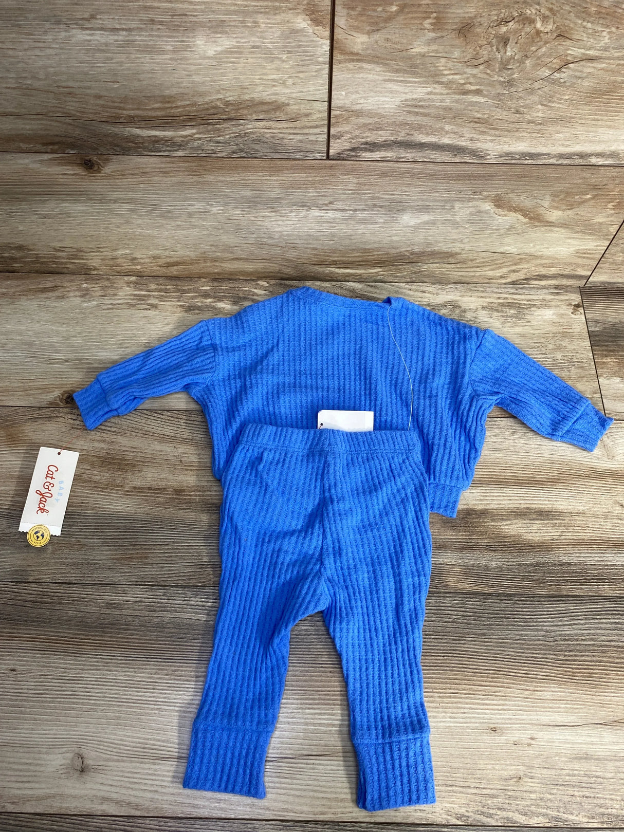 Blue waffle knit baby two-piece set with long sleeves and pants on wooden floor