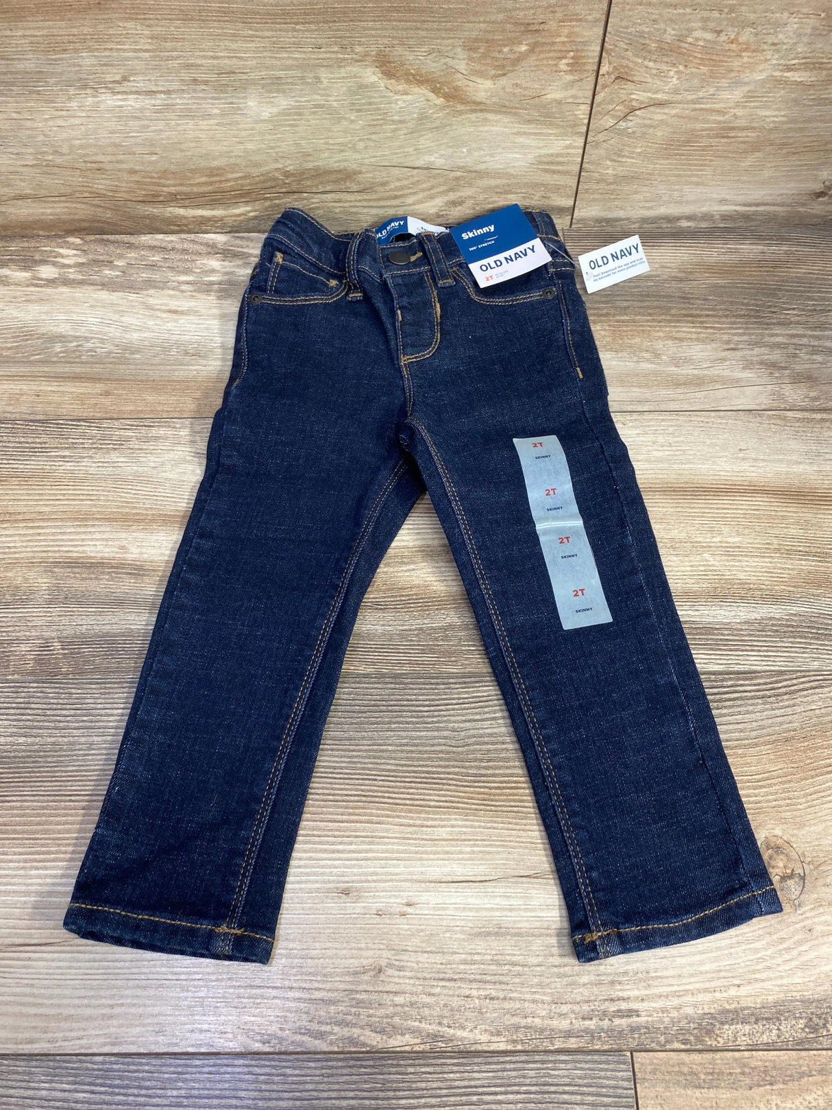 Toddler dark wash skinny jeans size 2T with tags on wooden background