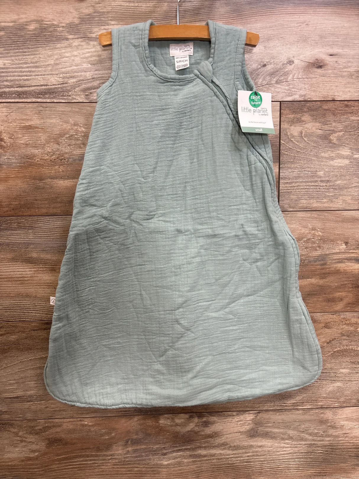 Front view of Little Planet green organic gauze sleepbag, sleeveless newborn (0-6M) with side zipper on wood background