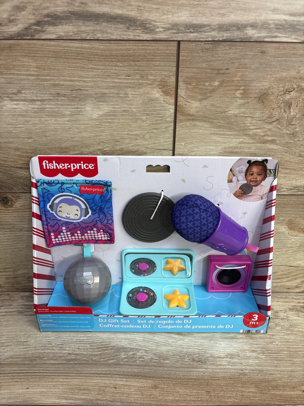 Front view of Fisher-Price Mini Me Moments DJ gift set with purple microphone, turntable, speaker and disco ball on wood background