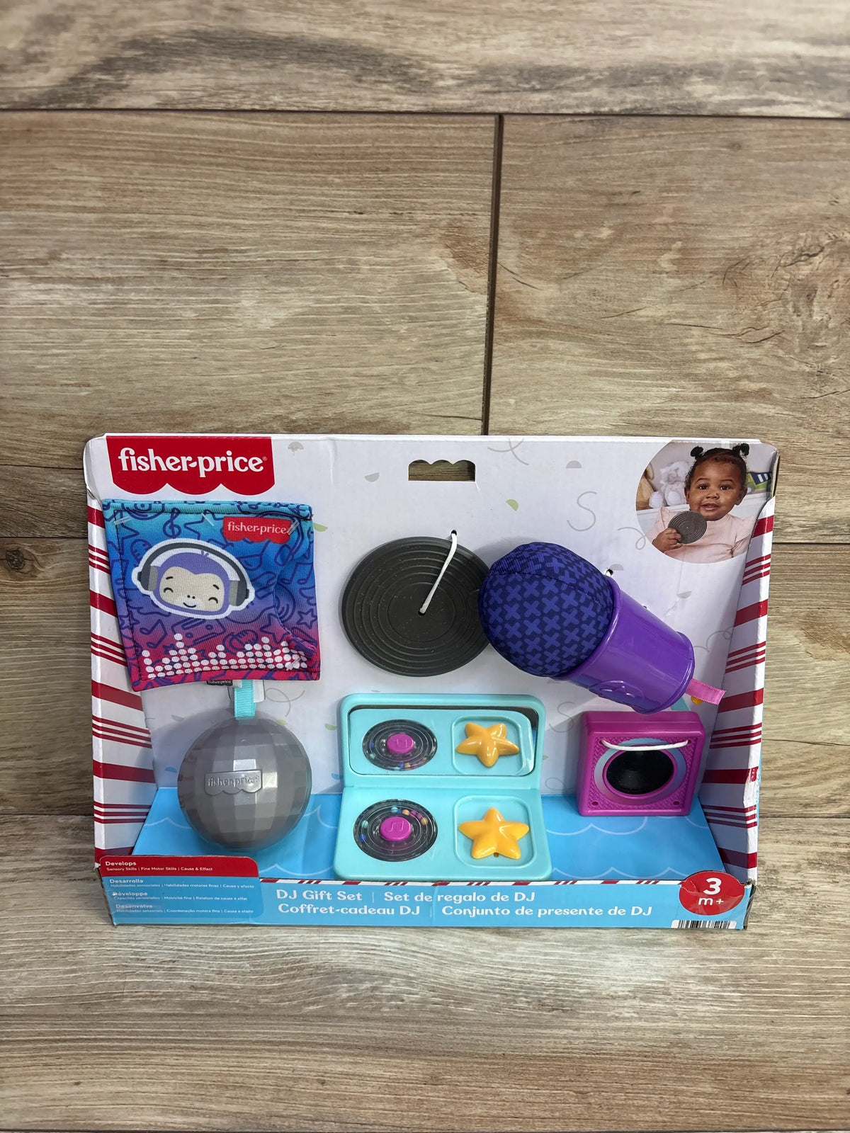 Front view of Fisher-Price Mini Me Moments DJ gift set with purple microphone, turntable, speaker and disco ball on wood background