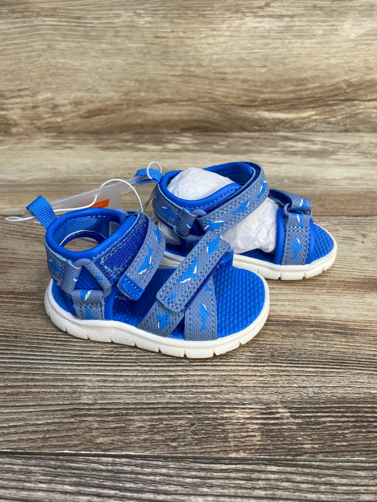 Blue and grey toddler sandals with white soles on wooden background, kids summer footwear