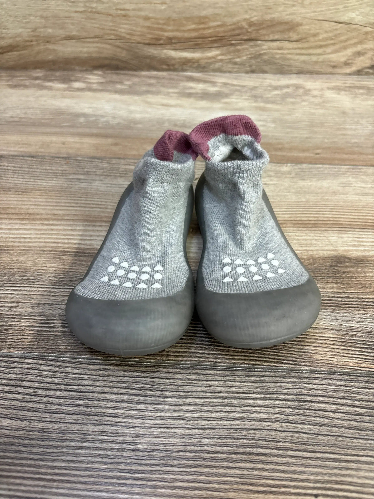 Front view of Bearbay baby sock shoes, grey with mauve cuff, size 7/8C, showing rubber toe and white non-slip dots on wood background