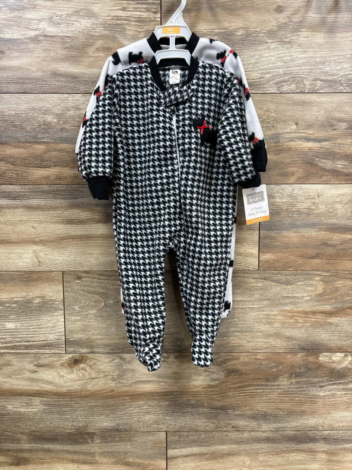 Two-piece baby sleeper set with black and white houndstooth and dog print on hangers