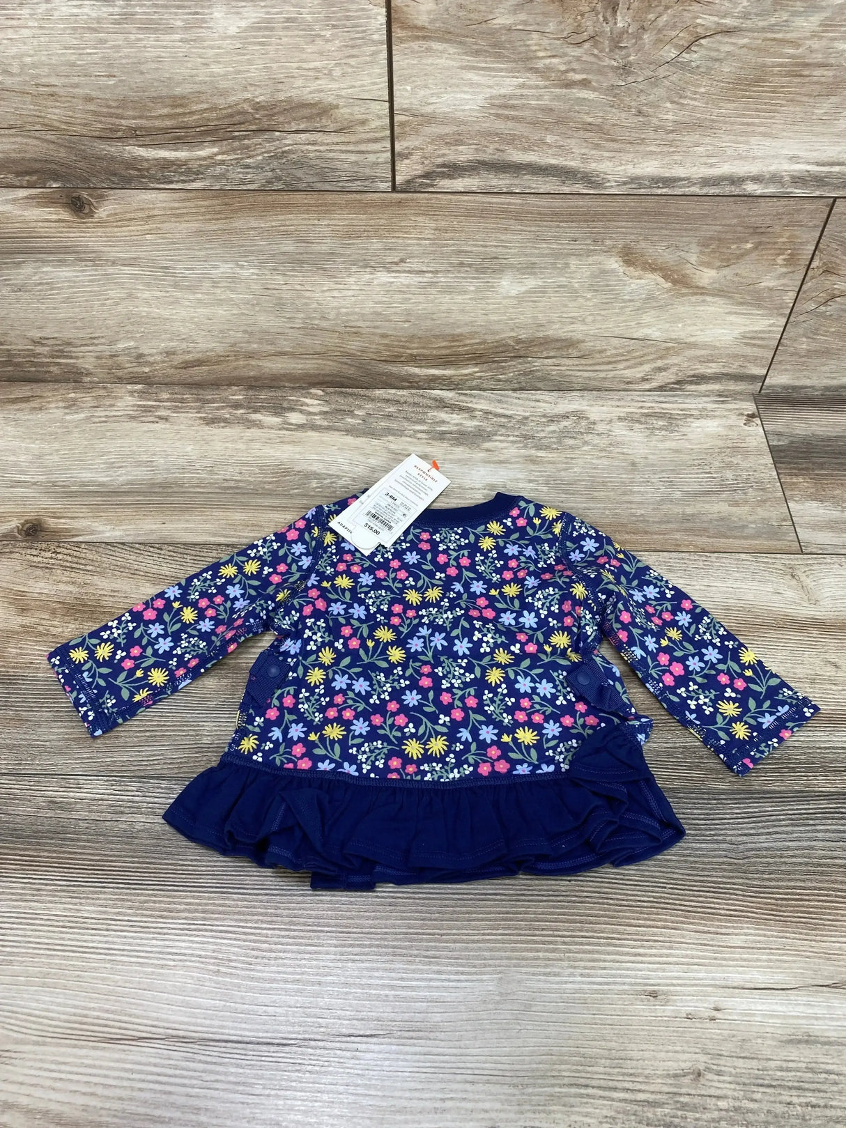 Front view of Cat & Jack navy floral peplum baby shirt showcasing peplum hem and adaptive design on white background