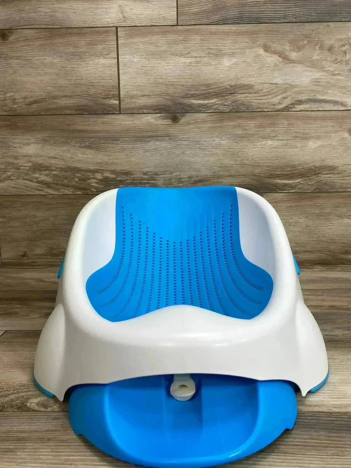 Front view of Munchkin Clean Cradle baby bathtub showcasing blue contoured drainable sling and white plastic cradle on wood floor background