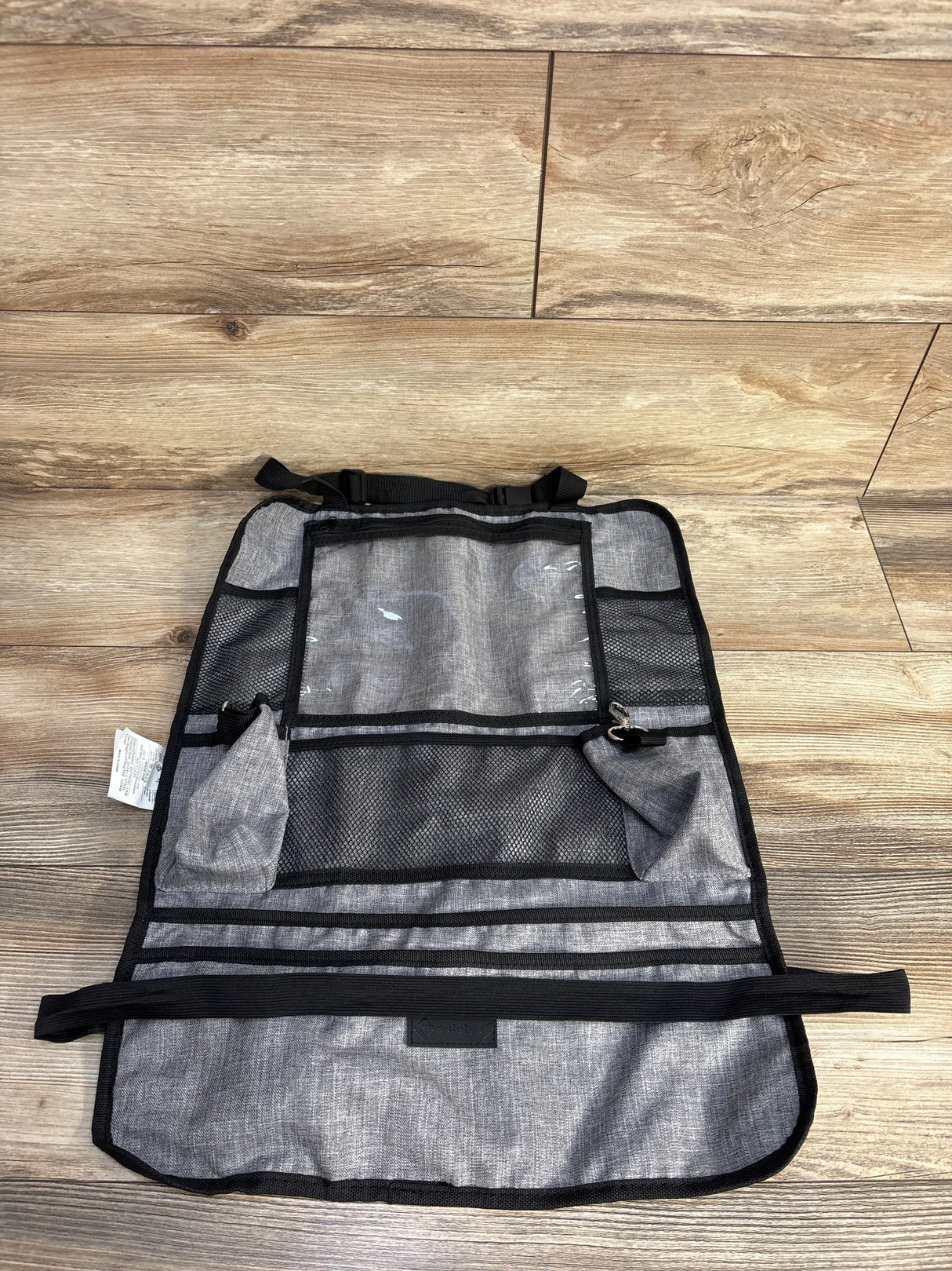Gray car seat back organizer with pockets on wood floor