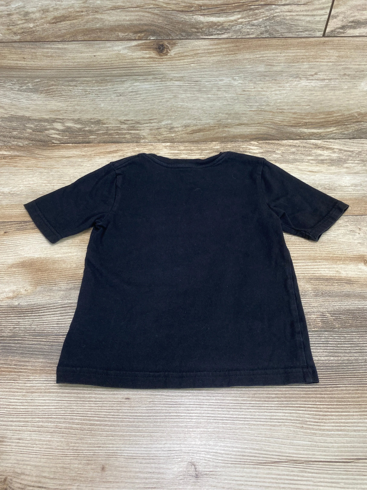 Back view of black toddler Super Bowl LVII T shirt size 4T showing short sleeves and crew neck on wood background