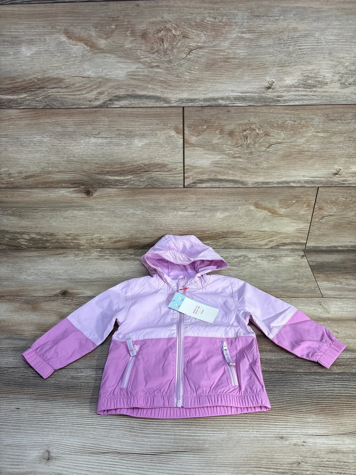Front view of Cat & Jack colorblock full-zip windbreaker jacket (12m) showing hood, zip pockets, elastic hem on wood background