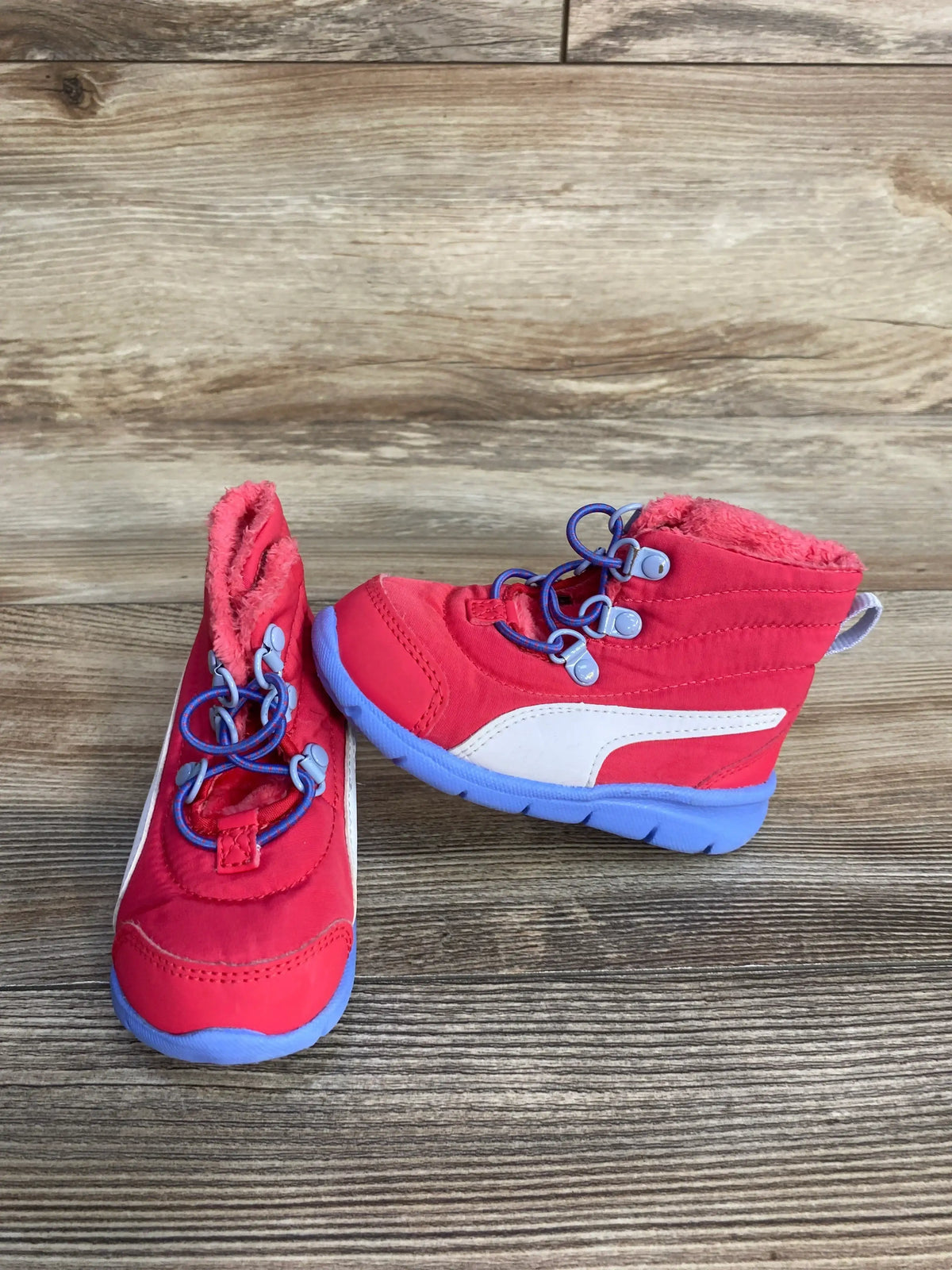 Side and front view of Puma Bao 3 AC toddler snow boots size 6C showcasing white Puma stripe, purple elastic laces and blue soles on wood floor
