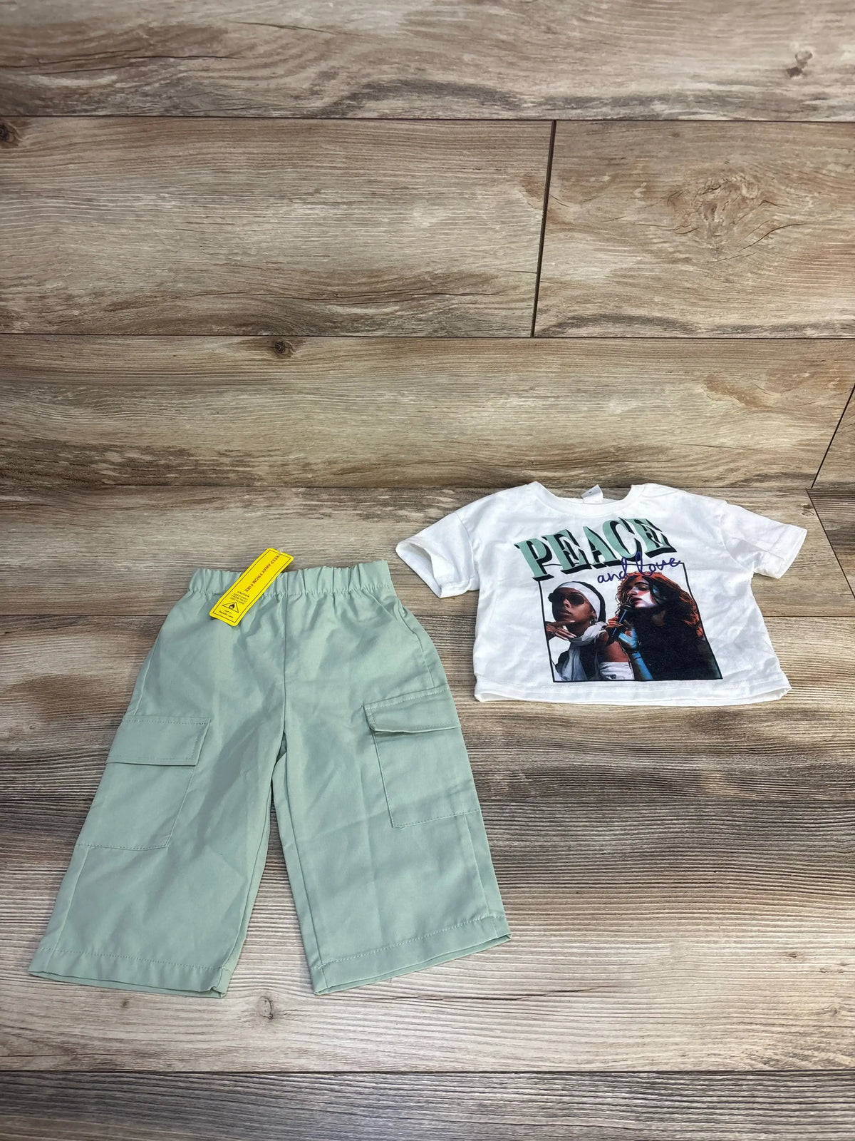 Kids mint green cargo pants with graphic t-shirt on wooden background