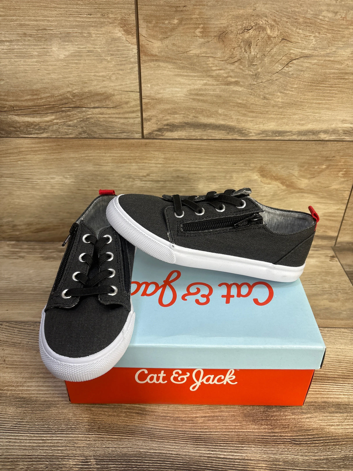 Angled view of Cat & Jack Lucian toddler grey sneakers size 1Y showing double side zippers and white soles on Cat & Jack box