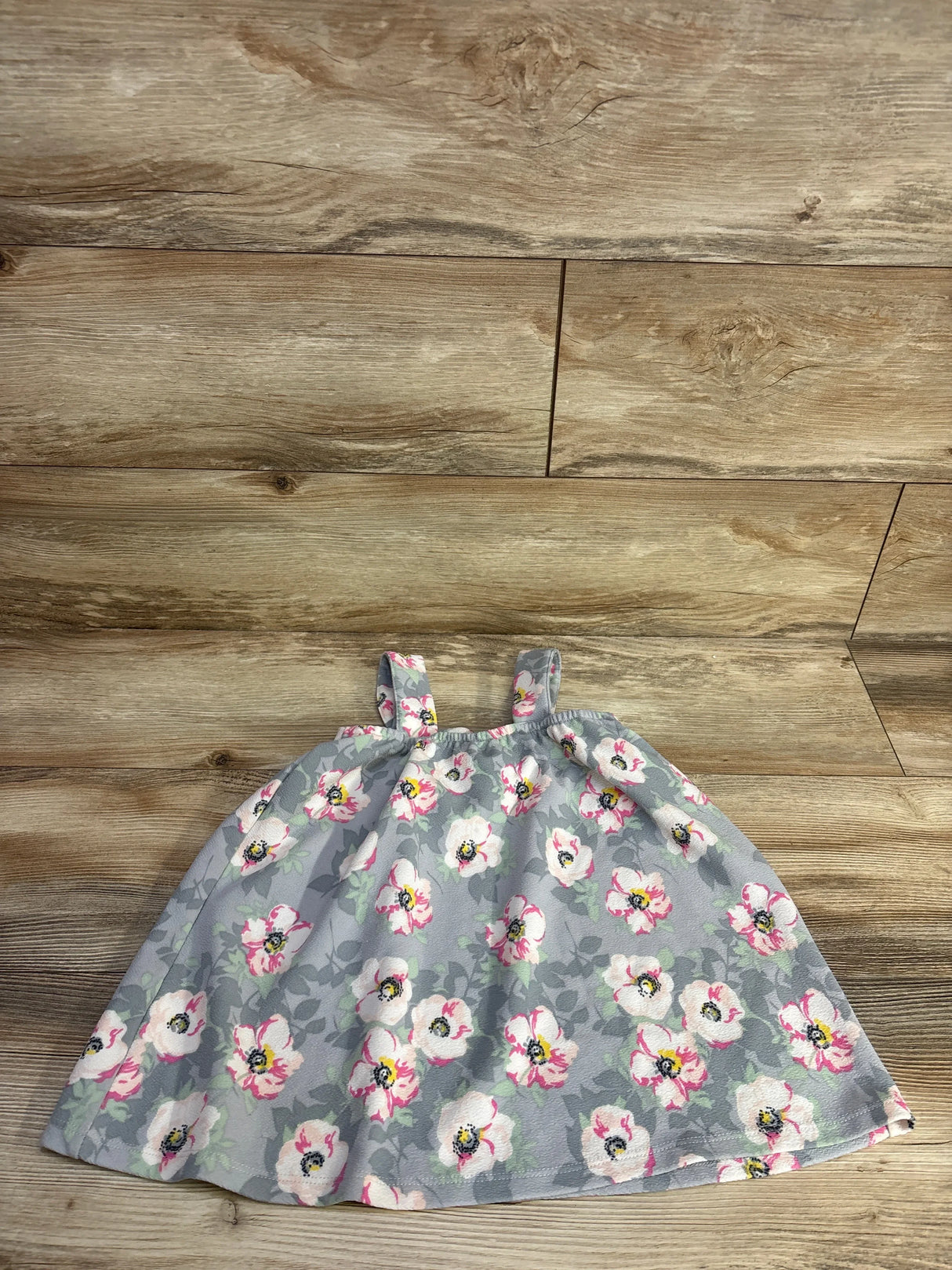 Flat lay of girls Madison Layne floral dress size 4T showcasing grey fabric with pink and white flowers on wood floor
