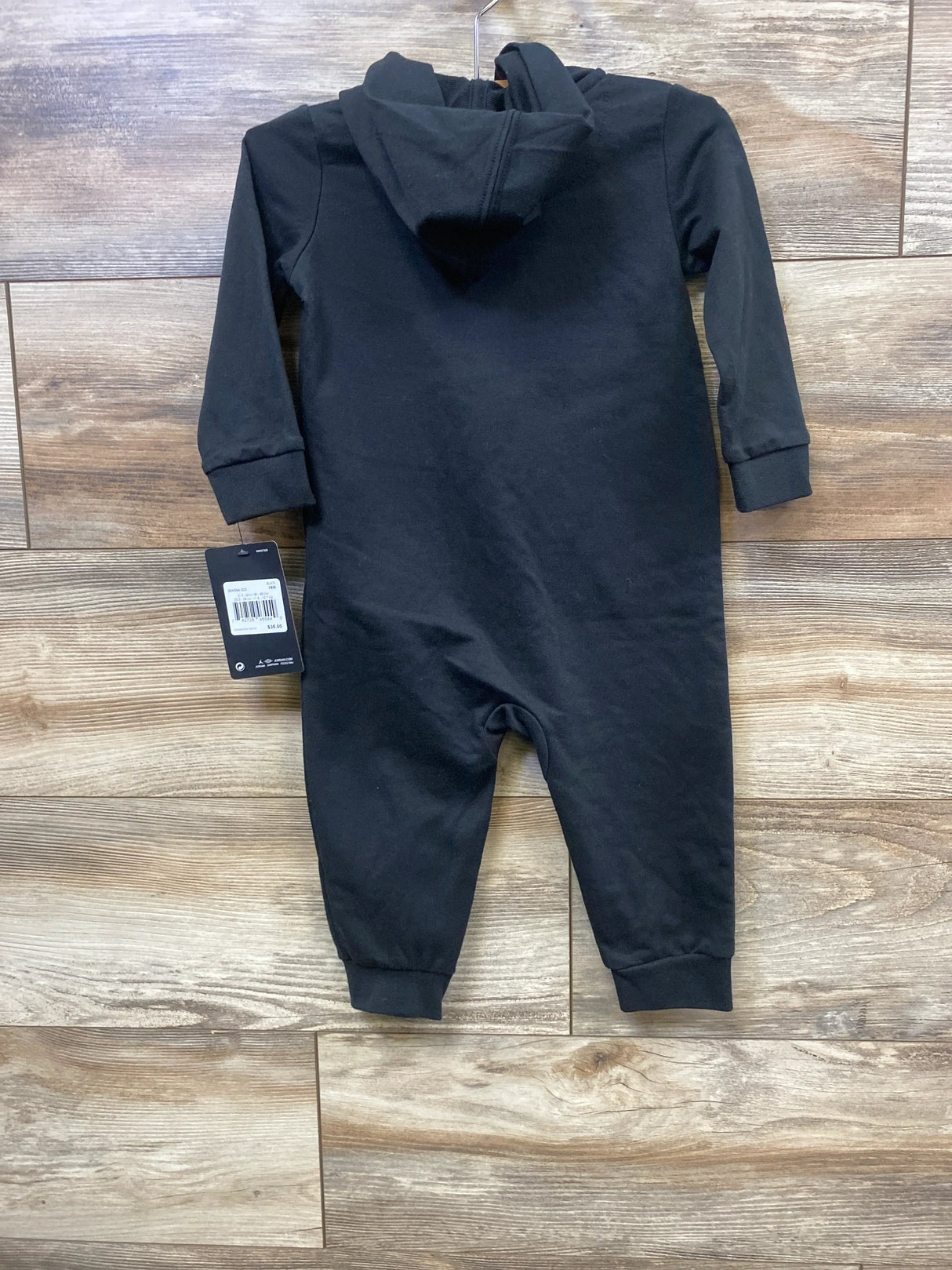 Black baby hooded romper with long sleeves, displayed on wood background, new with tag