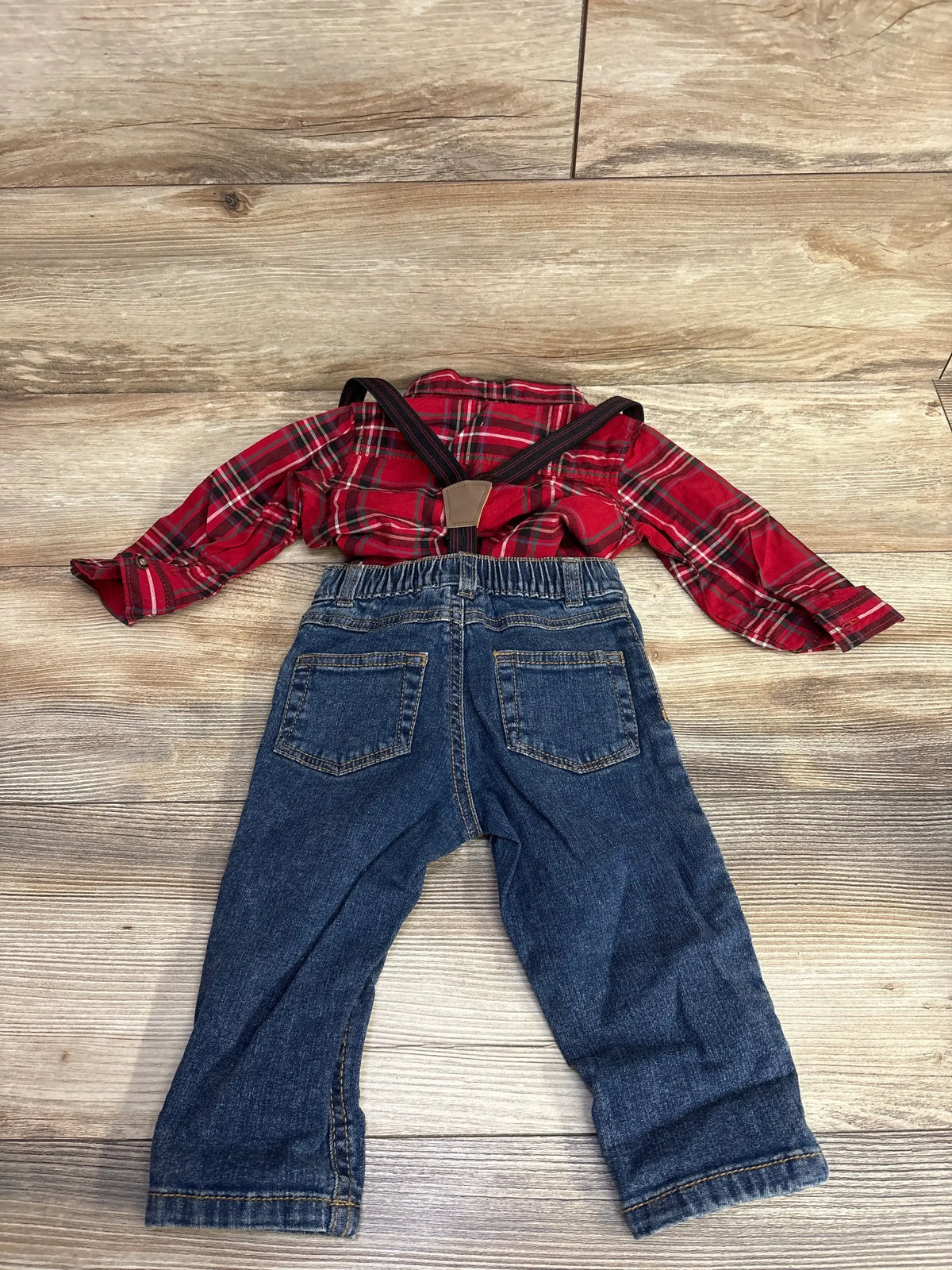 Red plaid toddler shirt with denim overalls, kids clothing set on wood floor