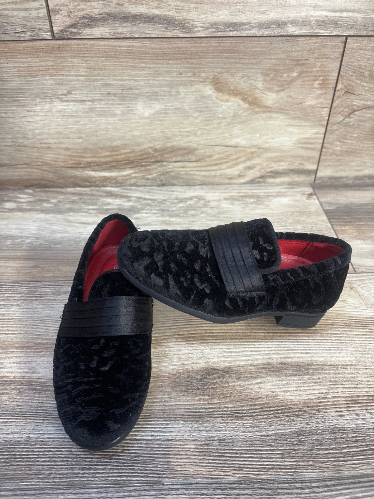 Overhead view of Bruno Marc tuxedo dress loafers in black, size 10C, showcasing slip-on bands on a wood-look floor