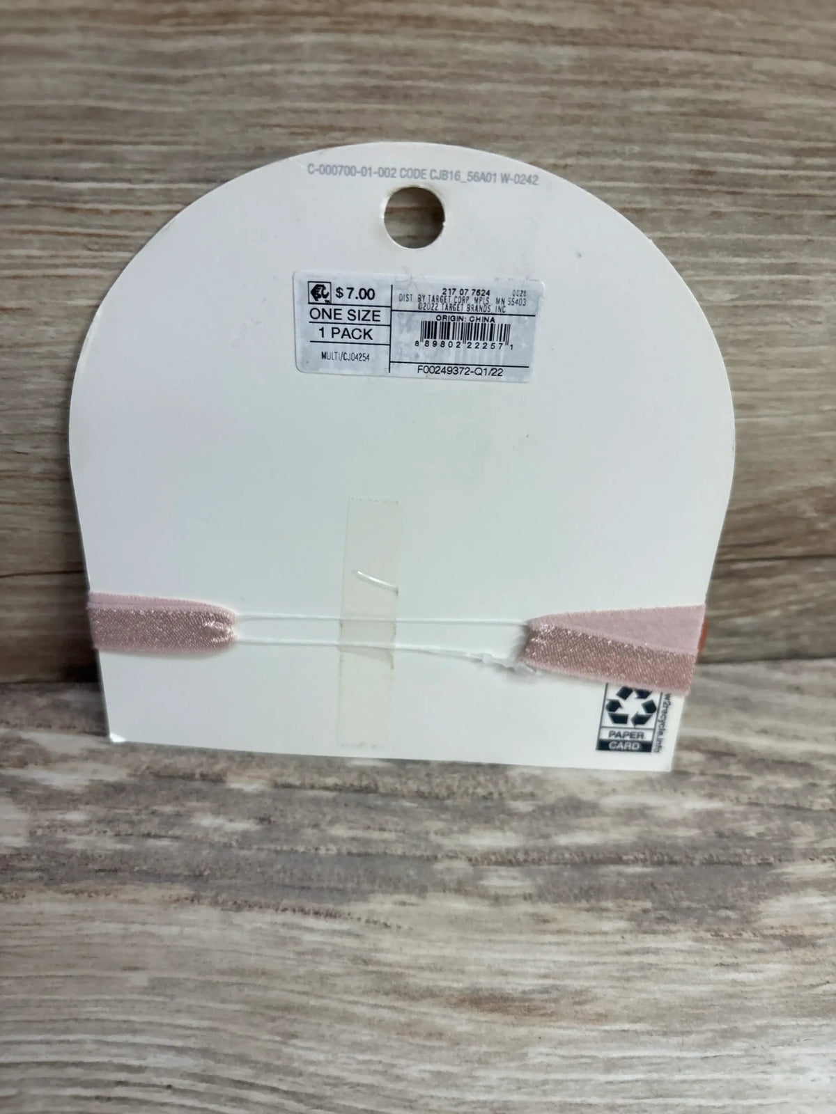 Back of Cat and Jack Doe head wrap showing pink elastic band on card with price sticker and ONE SIZE label on woodgrain