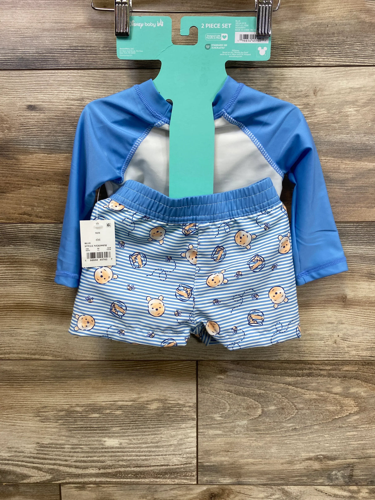 Blue baby swimwear set with cartoon bear prints and striped shorts, displayed on hanger