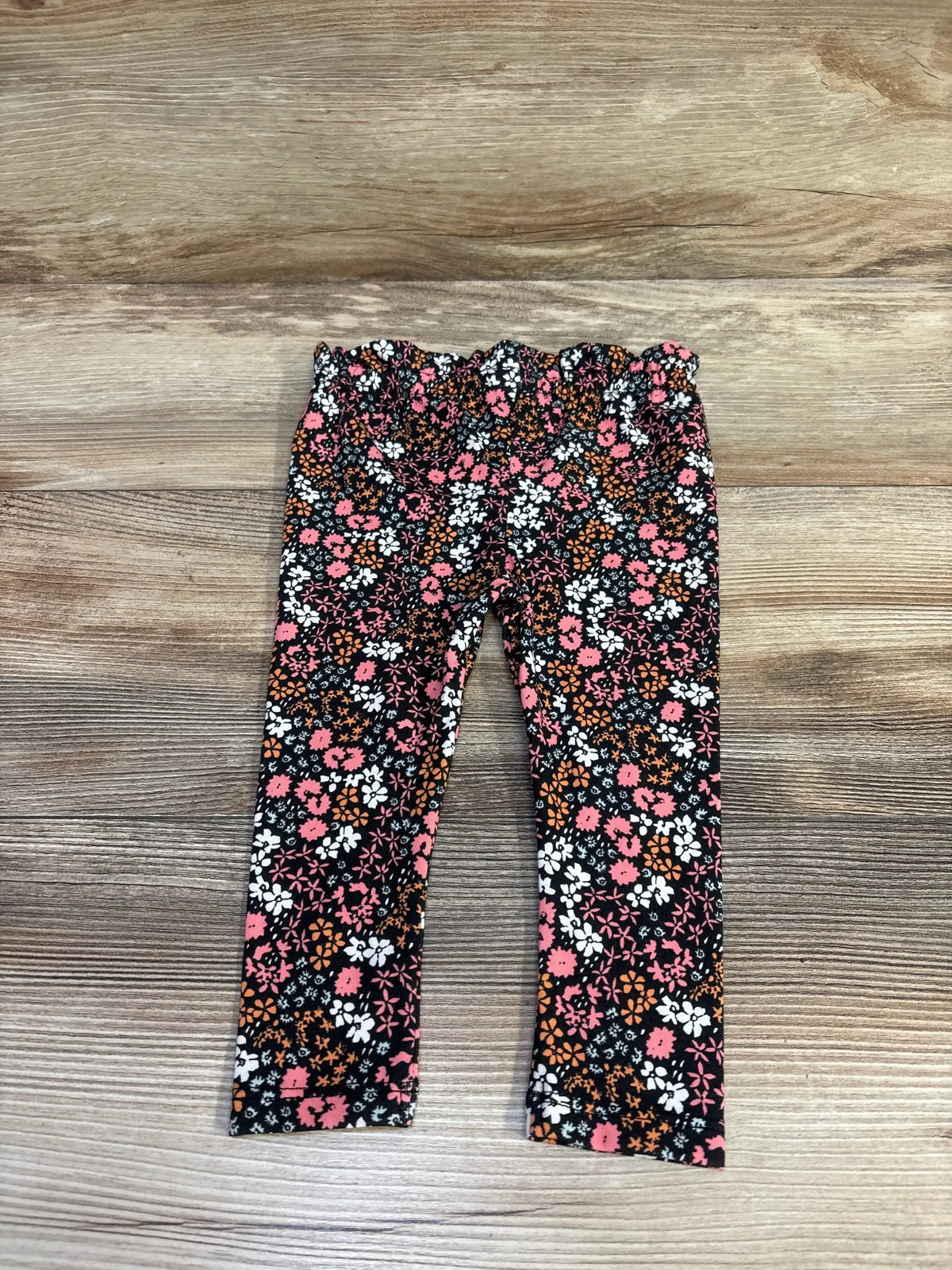 Front view of Cat and Jack baby floral leggings size 6-9m showing black with pink and white flowers on white background