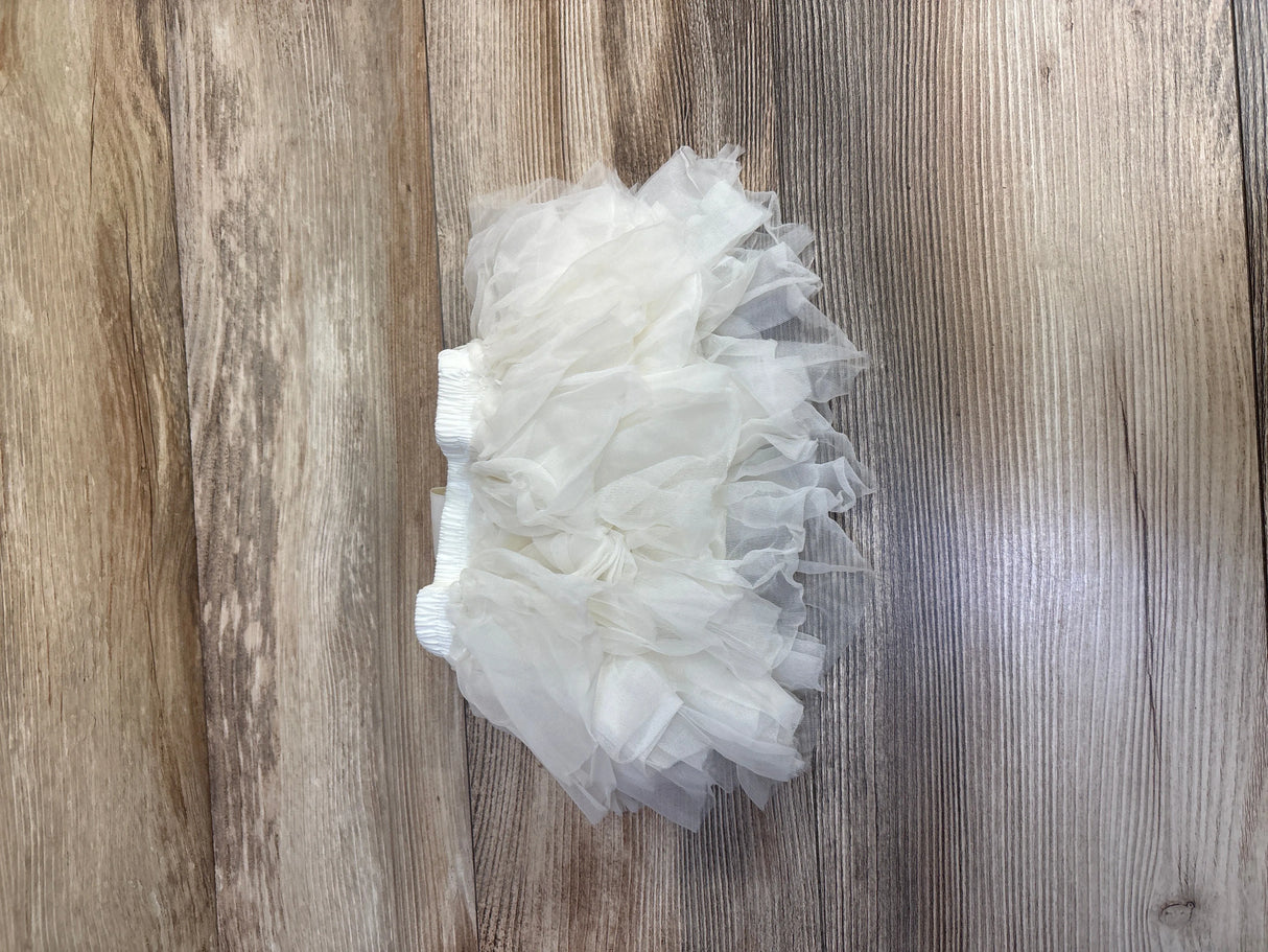 White ruffled tutu skirt with elastic waistband on wooden floor background