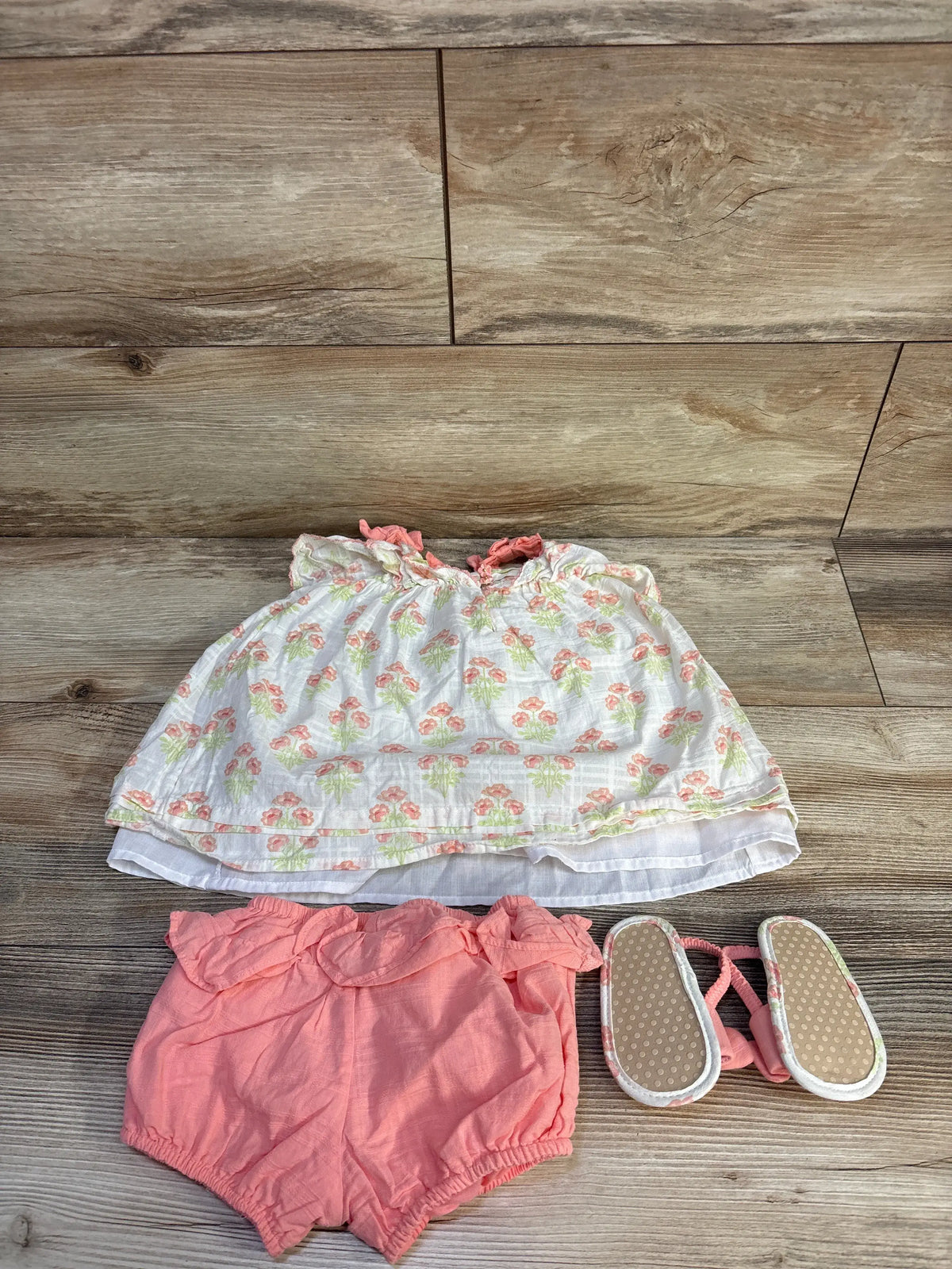 Top view of Haute Hippie three-piece floral dress set with white floral dress, pink bloomers, and sandals on wood