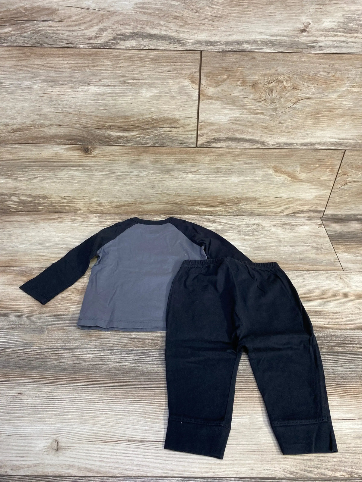 Top view of Baby Gap I Love My Mummy shirt and pants set in black, with long sleeves and elastic waist on wood flooring