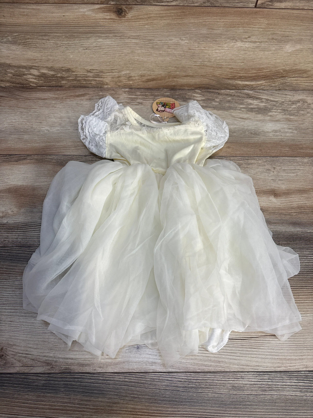 White lace short sleeve toddler dress with tulle skirt on wooden background