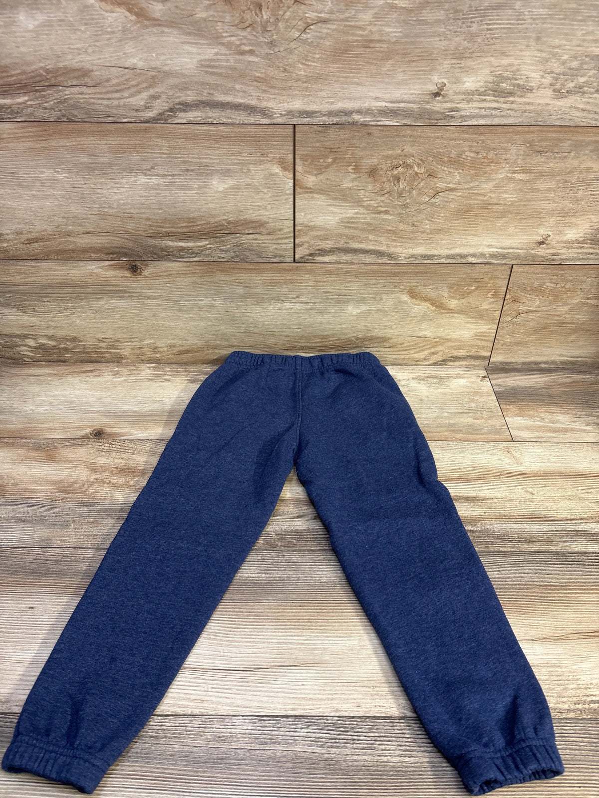 Flat lay of Cat & Jack navy toddler joggers showing elastic waistband, drawstring, and cuffed ankles on wood floor