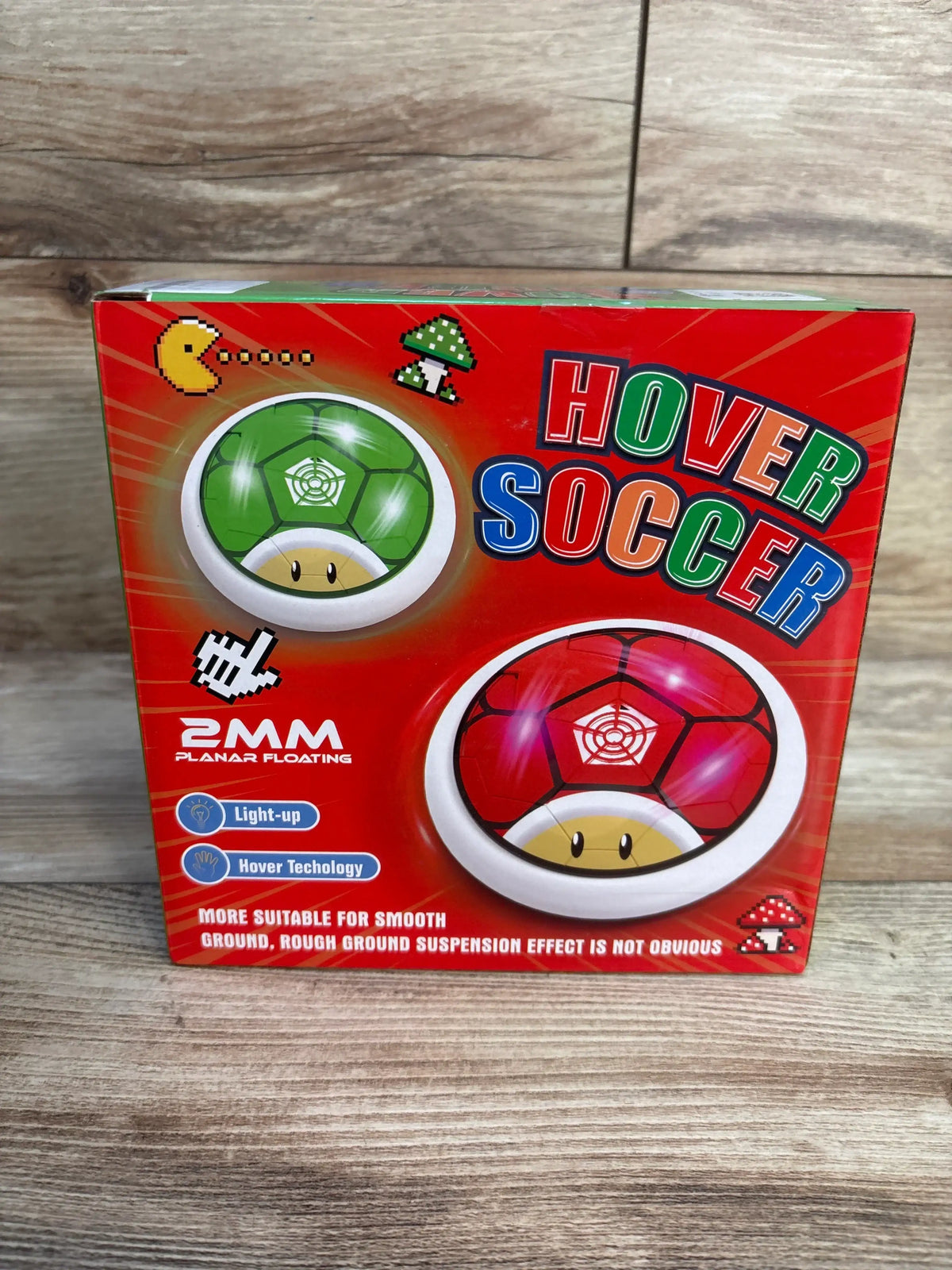 Hover Soccer toy box with red and green light-up hover balls for kids, wood background