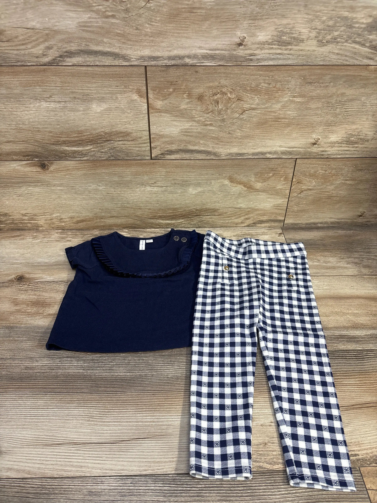 Front view of Janie and Jack 2-piece outfit showcasing navy pleated-trim top and gingham ponte pants with gold-tone buttons