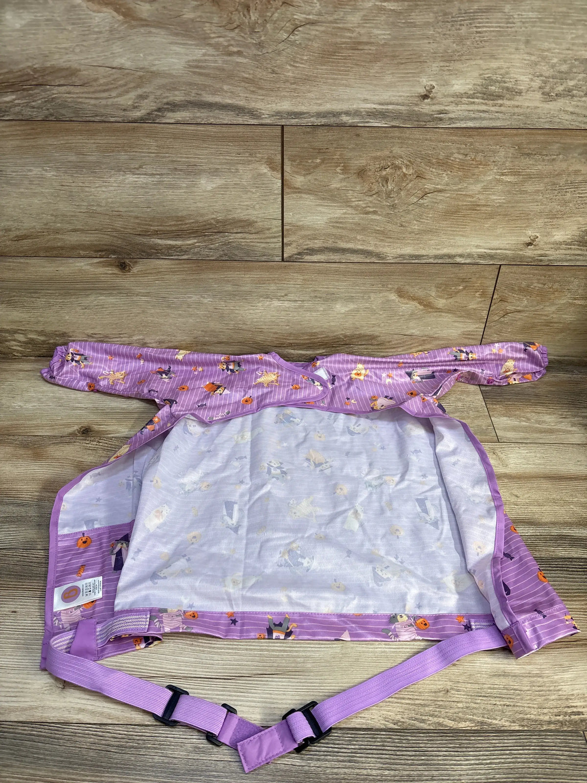 Top view of Bibado Coverall Weaning Bib in purple Animal Halloween print, with long sleeves and adjustable waist strap