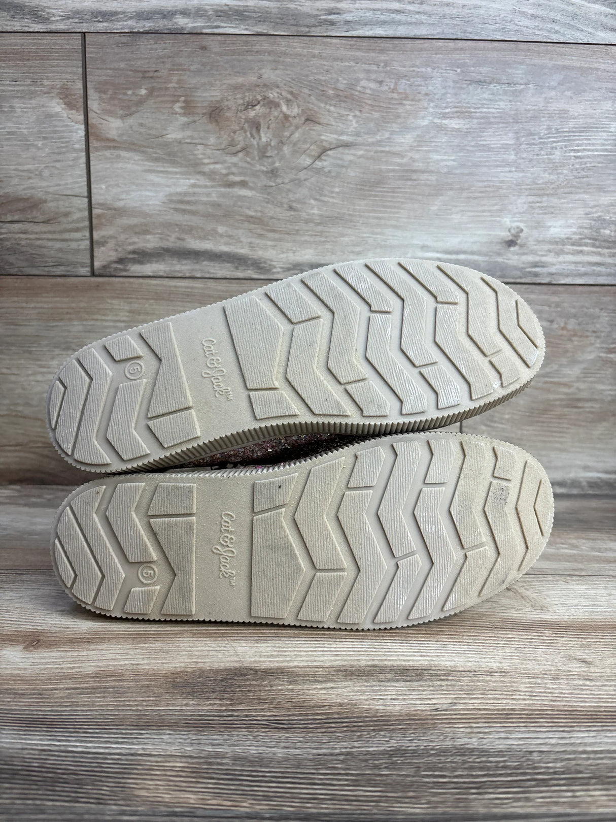 Cat & Jack toddler shoes soles with zigzag tread, size 6, on wooden floor