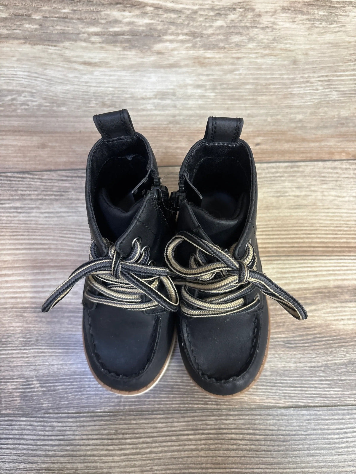 Top view of Cat and Jack Greyson black boots, size 6C, showcasing bungee laces and hook and loop closure on wood