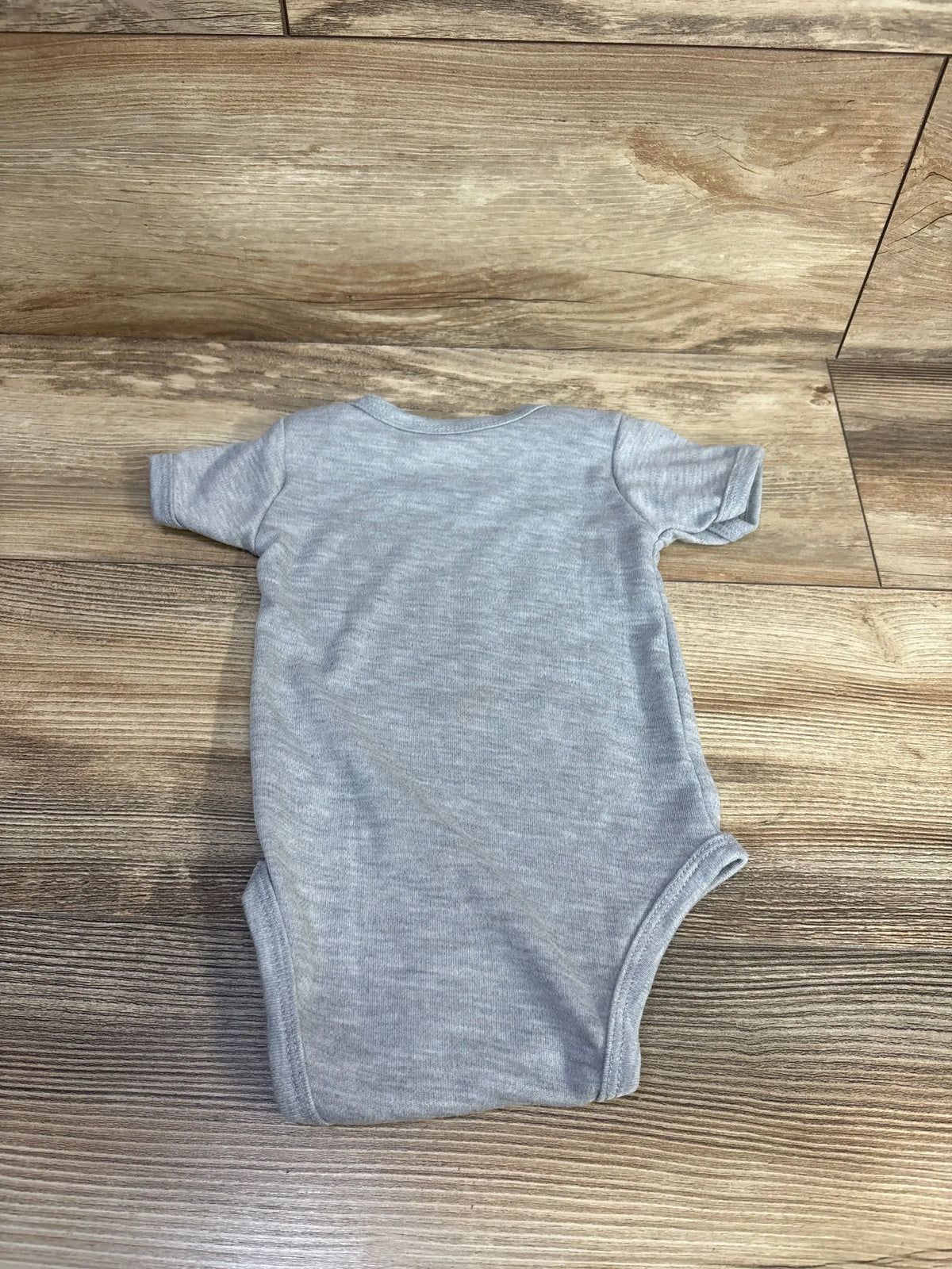 Back view of Viuluti grey bodysuit (6m) showcasing short sleeves and heathered knit fabric on wood floor