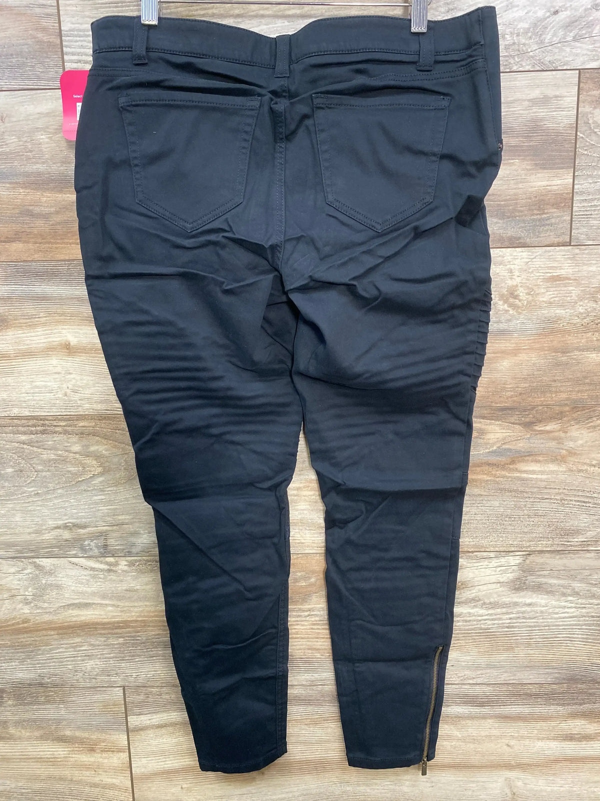 Back view of black Isabel maternity utility jeggings showcasing back pockets, slim fit and ankle zipper on wooden floor