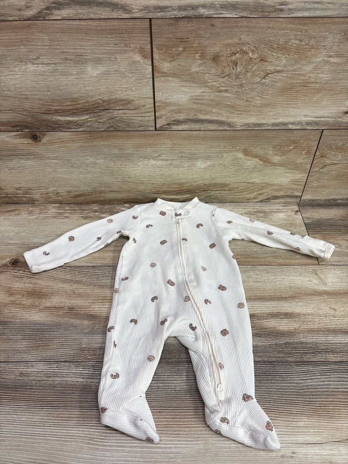 Front view of Carter’s waffle knit sleeper showcasing long sleeves, footed legs, brown pattern, and front zipper on ivory fabric