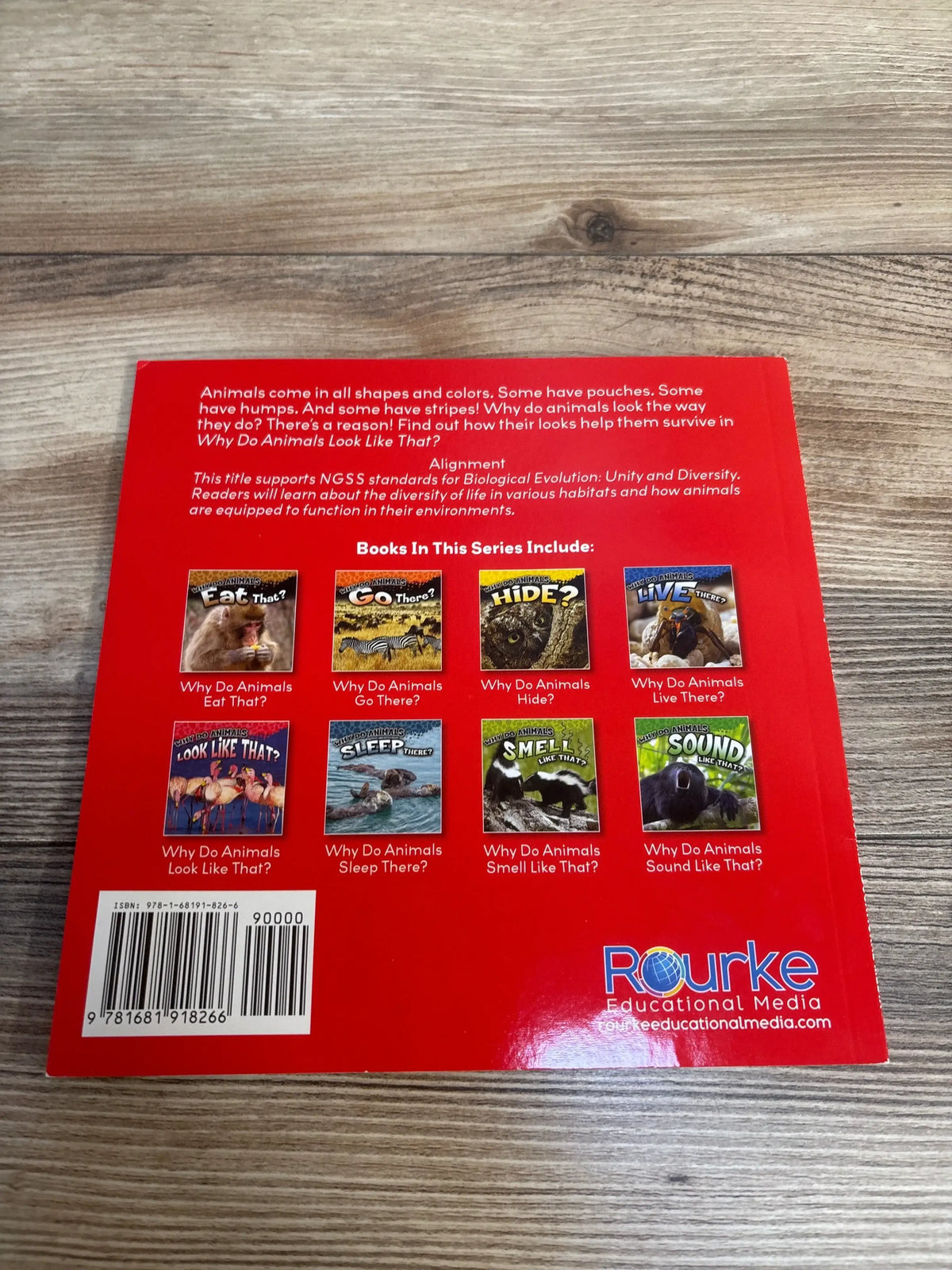 Back cover of Why Do Animals Look Like That? paperback showing colorful series titles and barcode on a wood table